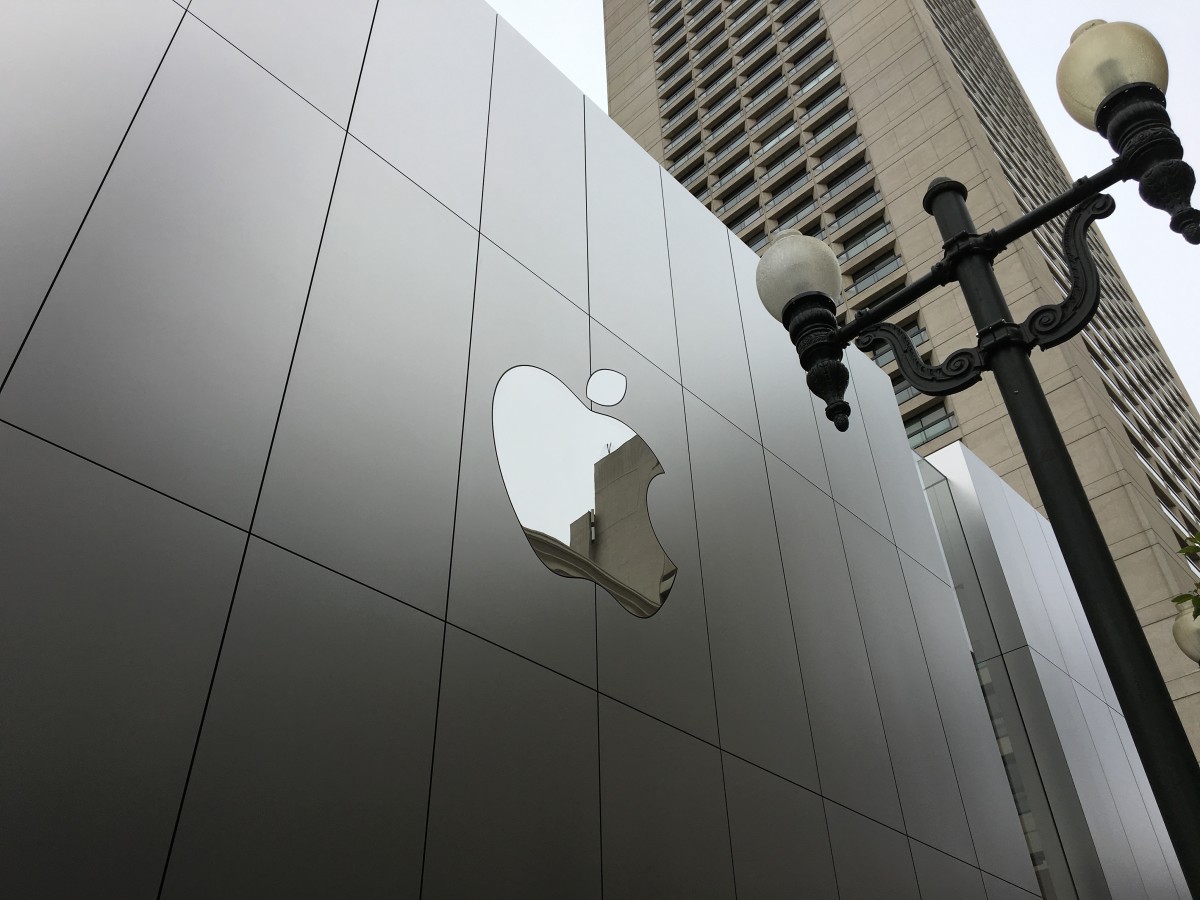 以前白色发光的苹果标志放在 Apple Store 正中央。苹果不再发光发亮，移到商店的旁边，改用银色镜面设计。