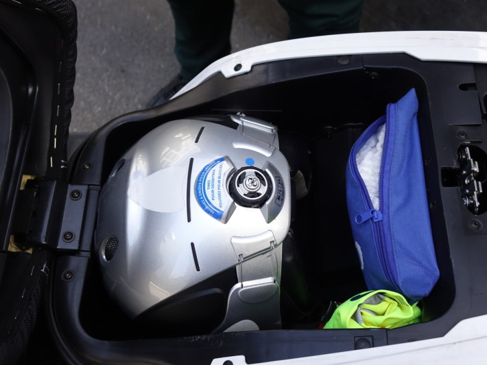 解锁后可打开车辆，取出头盔。基于卫生问题，旁边的蓝色小袋内有用完即弃头套供应。