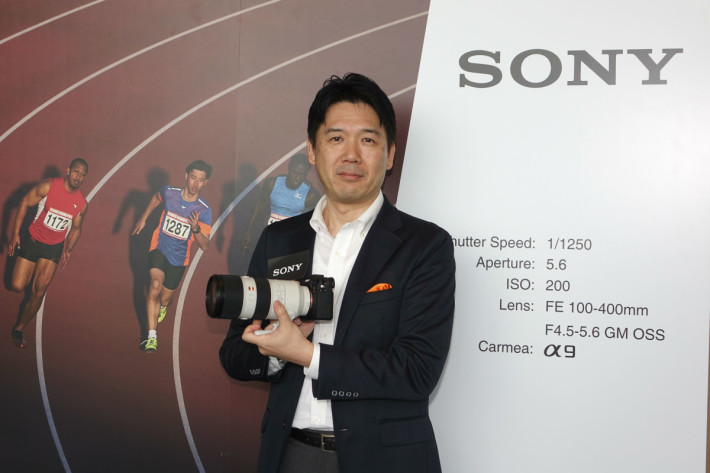 Sony 数码影像本部高级总经理田中健二拿起配上 100-400mm 的 A9。