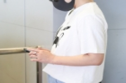马丽婚后现身机场 靠墙壁刷手机秀钻戒似与老公传情
